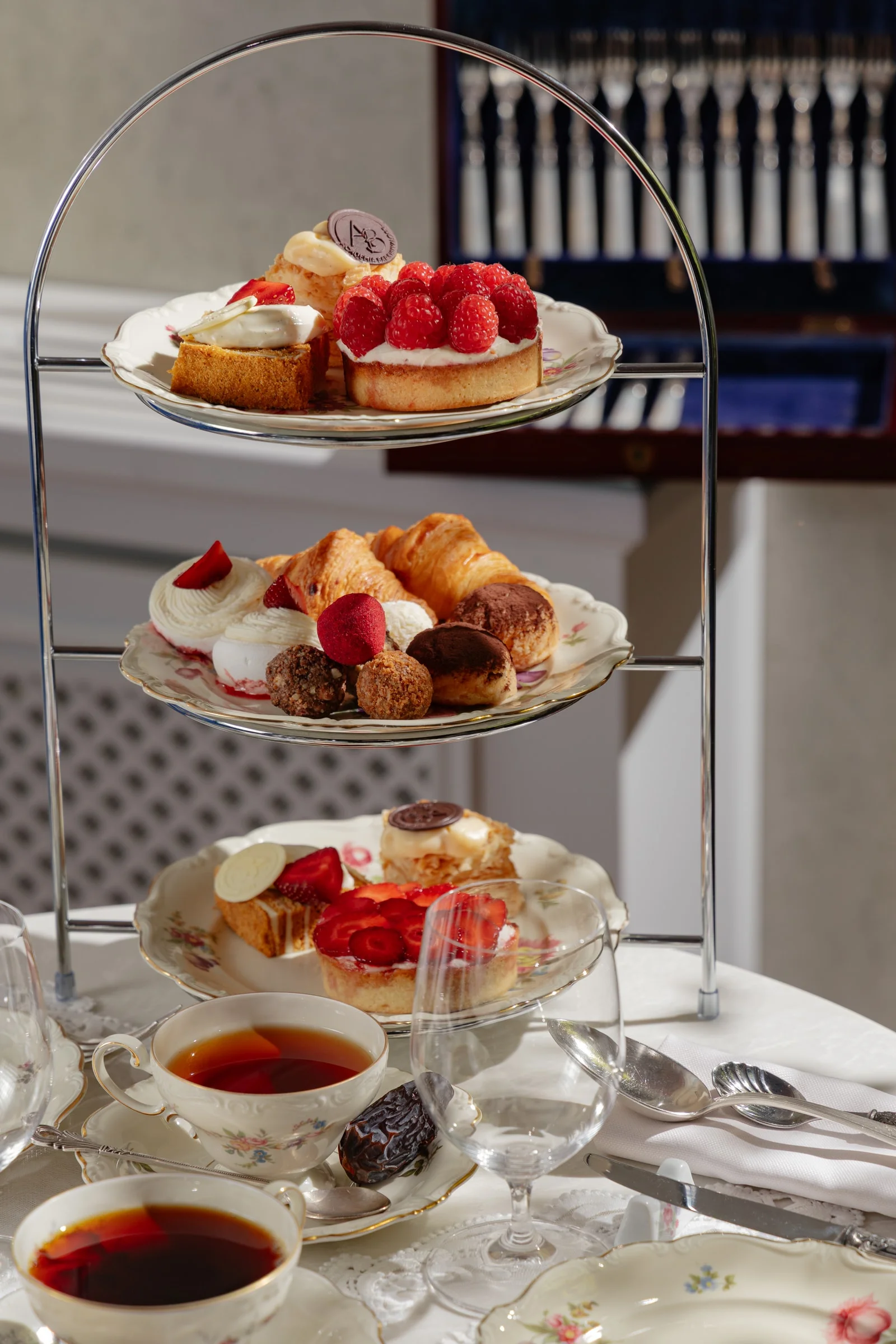 Three-tier stand with desserts, berry tartlets and mini croissants on a tea table at the Shuvaloff Mansion